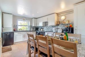 a kitchen with white cabinets and a table with chairs at 2 Bed in Wells-next-the-Sea oc-2032 in Wells next the Sea