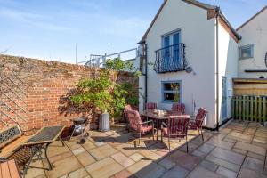 a patio with a table and chairs and a brick wall at 2 Bed in Wells-next-the-Sea oc-2032 in Wells next the Sea