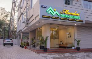 a building with a green mountains sign on it at Munderi Green Mounts - Family Rooms with Pool, Wayanad, Kalpetta in Kalpetta