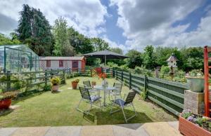 a patio with a table and chairs in a garden at 1 Bed in Ilfracombe oc-n2052 in Berrynarbor