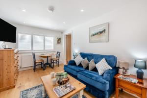 a living room with a blue couch and a table at 1 Bed in Yapton oc-b32757 in Yapton