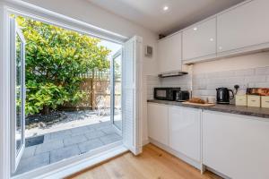 a kitchen with white cabinets and a large window at 1 Bed in Yapton oc-b32757 in Yapton +12 photos
