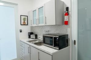 a kitchen with a sink and a microwave at Relax San Juan in San Juan