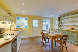 a kitchen with a wooden table and chairs in it at 2 Bed in Walberswick oc-hhock in Walberswick