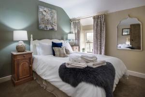 a bedroom with a large bed with white sheets and a mirror at 2 Bed in Pwllheli oc-30aber in Pwllheli