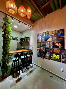 a kitchen with a bar with stools and paintings on the wall at Vibe Amazon in Manaus