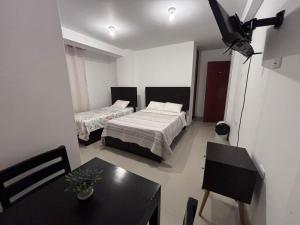 a room with two beds and a table and a dining room at Hotel Munay in Paracas +27 photos