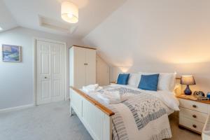 a bedroom with a large bed with blue pillows at 3 Bed in Broad Haven oc-t30529 in Broad Haven