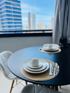 a table with plates and utensils on top of it at Mercure1906 - Piscina aquecida, edifício com estrutura de hotel 4 estrelas in Salvador