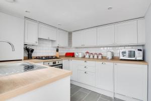 a white kitchen with white cabinets and white appliances at 2 Bed in Southwold oc-eastgn in Southwold