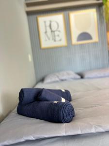 a blue rolled up towel sitting on a bed at Mercure1906 - Piscina aquecida, edifício com estrutura de hotel 4 estrelas in Salvador