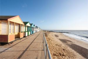 a row of beach houses on a sandy beach at 2 Bed in Southwold oc-eastgn in Southwold