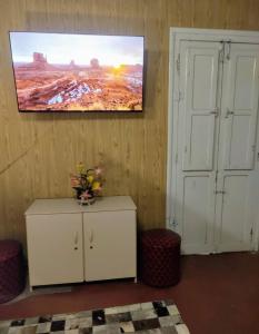 a living room with a tv on the wall and a cabinet at Posada Dale Dale in São Gabriel +8 photos