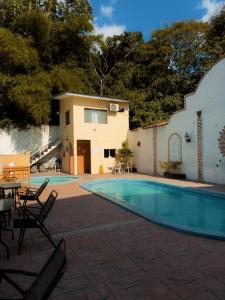 a swimming pool with chairs and a house at Hotel Condesa in Comayagua
