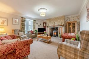 a living room with couches and a fireplace at 5 Bed in Biddlestone oc-b30105 in Alnham
