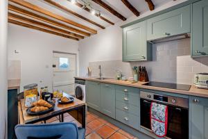 a kitchen with green cabinets and a table with bread on it at 2 Bed in Lavenham oc-f30054 in Lavenham