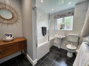 a bathroom with a tub and a toilet and a sink at 5 Bed in Biddlestone oc-b30105 in Alnham +39 photos