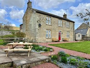 an old stone house with a picnic table in front of it at 5 Bed in Biddlestone oc-b30105 in Alnham