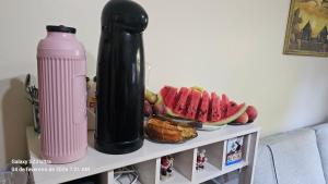 ein Tisch mit einer Wasserflasche und einem Teller Essen in der Unterkunft Mimi Nova in Osório
