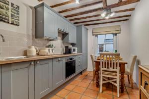 a kitchen with white cabinets and a table and a tableablish at 2 Bed in Lavenham oc-t30056 in Lavenham
