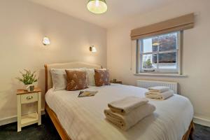 a bedroom with a large white bed with towels on it at 2 Bed in Lavenham oc-t30056 in Lavenham