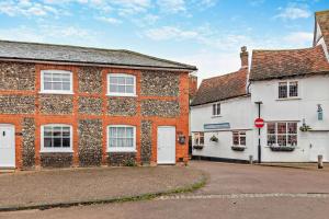 two old brick buildings with white doors on a street at 2 Bed in Lavenham oc-t30056 in Lavenham