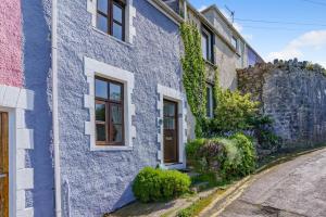 a blue house with a stone wall at 2 Bed in Mumbles oc-l31146 in The Mumbles