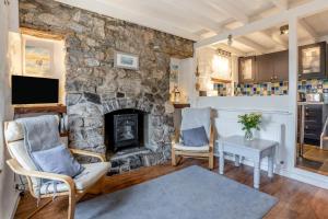 a living room with a stone fireplace and two chairs at 2 Bed in Mumbles oc-l31146 in The Mumbles