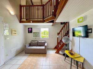 a living room with a couch and a tv at Bungalows Arc en Ciel in Sainte-Anne