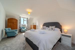 a bedroom with a large bed and a blue chair at 3 Bed in Clachan oc-h32242 in Clachan