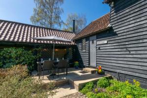 a patio with a table and an umbrella next to a house at 2 Bed in Rumburgh oc-dgf in Rumburgh