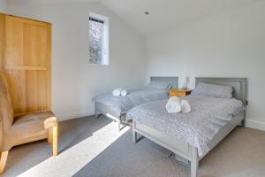 a bedroom with two beds and a chair at 2 Bed in Sotherton oc-dailo in Blyford