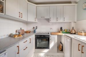 a white kitchen with white cabinets and an oven at 2 Bed in Halesworth oc-rect in Halesworth