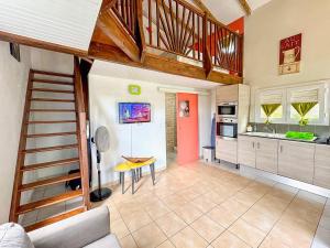 a kitchen with a staircase leading to a room at Bungalows Arc en Ciel in Sainte-Anne