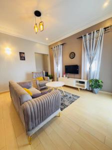 a living room with a couch and a table at Dreamy Den Suites Kiwatule in Kampala