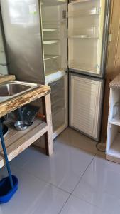 a kitchen with an open refrigerator and a sink at Rukas Huinkaray in Pucón