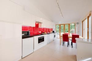 a kitchen with white cabinets and a table with red tiles at 2 Bed in Stelling Minnis oc-ek715 in Lyminge