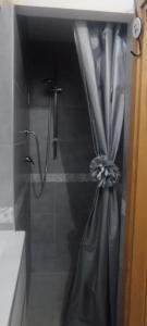 a shower with a shower curtain in a bathroom at Mariposa in Capodimonte +13 photos