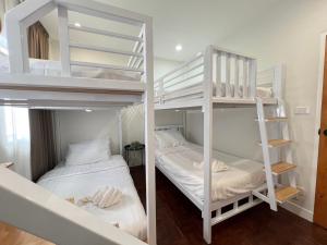 two bunk beds in a room with two beds at แสงจันทร์พลูวิลล่าระยอง in Ban Thung Haeo
