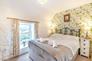 a bedroom with a bed with white sheets and a window at 2 Bed in Swansea oc-hh403 in Llanmadoc