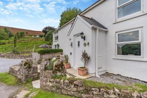 a white house with a stone wall at 2 Bed in Swansea oc-hh403 in Llanmadoc
