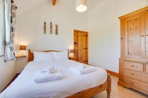 a bedroom with a white bed with two towels on it at 2 Bed in Roughton oc-1734 in Roughton