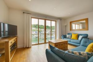 a living room with a blue couch and a television at 2 Bed in Porthleven oc-4stelv in Porthleven