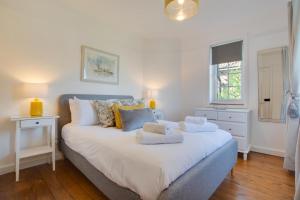 a bedroom with a large white bed with towels on it at 5 Bed in Mundesley oc-2189 in Mundesley