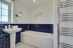 a bathroom with a white tub and a sink at 5 Bed in Mundesley oc-2189 in Mundesley +12 photos