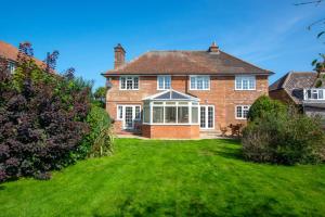 a large brick house with a grass yard at 5 Bed in Mundesley oc-2189 in Mundesley