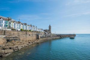 a river with houses and a boat in the water at 2 Bed in Porthleven oc-4stelv in Porthleven