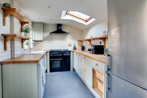 a kitchen with white cabinets and a black appliance at 3 Bed in Cromer oc-1670 in Cromer +11 photos