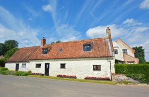a white house with a red roof on a street at 2 Bed in Colkirk oc-1397 in Colkirk