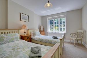 a bedroom with two beds and a desk and a window at 4 Bed in Lynmouth oc-marins in Barbrook